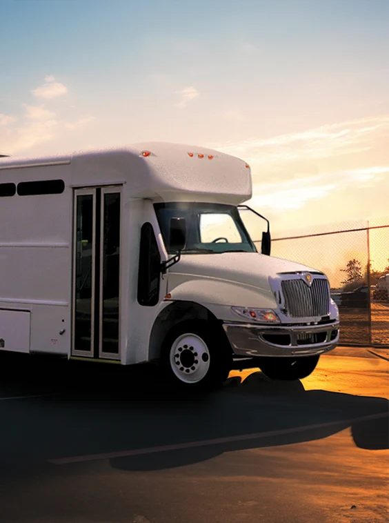 White shuttle bus parked next to a security fence at a prison near Duncan