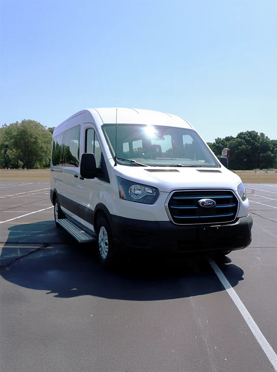 white shuttle transit bus parked in a parking lot 